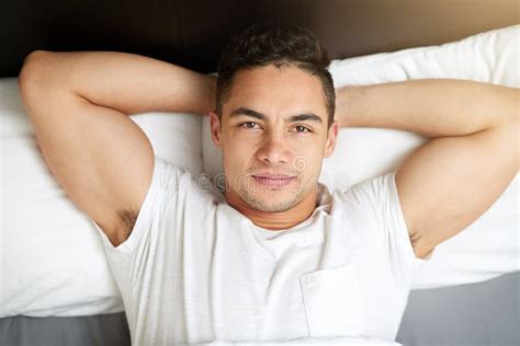 Just Lay Back And Relax A Handsome Young Man Lying In Bed Stock Image