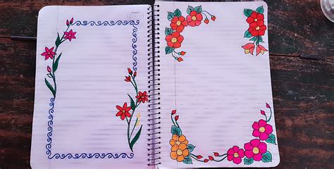 An Open Notebook With Flowers On It Sitting On A Wooden Table Next To A