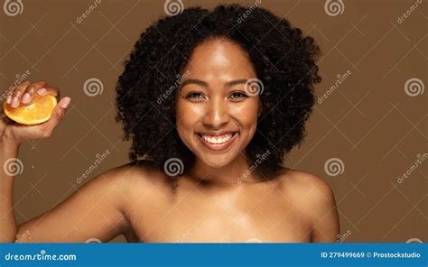 Happy Topless African Lady Squeezing Half Of Orange Brown Background