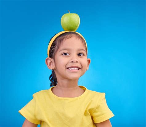 Sonrisa De Retrato Y Ni A Con Manzana En La Cabeza Sobre Fondo Azul