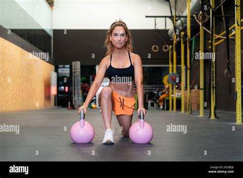 Female Athlete Performing Forward Lunge During Workout With Weights