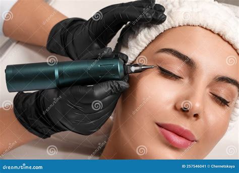 Young Woman Undergoing Procedure Of Permanent Eyeliner Makeup Closeup