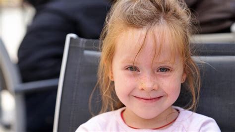 Premium Photo Close Up Portrait Of Cute Girl Smiling While Sitting On