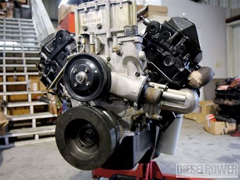 An Engine Is Sitting On A Stand In A Garage With Boxes And Pallets