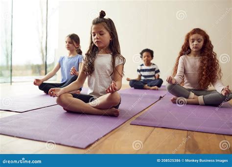 Group of Children Sitting on Exercise Mats and Meditating in Yoga ...