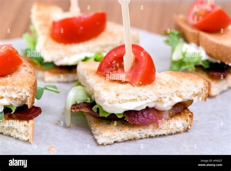 A Gourmet Blt Sandwich Cut Into Wedges With A Small Tomato On Top Stock