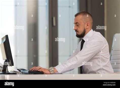 Portrait Of A Young Business Man Using A Computer In The Office Stock Photo - Alamy