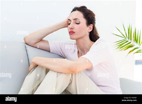 Sad Brunette Sitting On The Couch Stock Photo Alamy