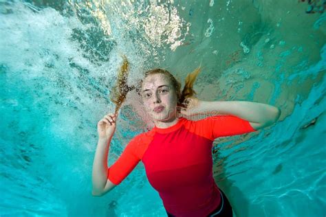 Una Muchacha Feliz En Un Traje De La Sirena Miente En El Agua Entre Las Piedras En La Playa Y