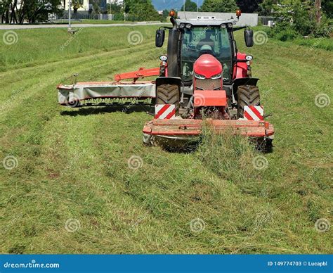 Red Tractor With A Rotary Disc Mower Cutting The Grass Of A Fallow Field Stock Image Image Of