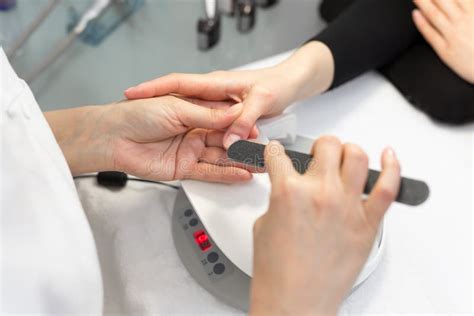 Manicure Close Up Of Female Hands Filing Nails With Nail File In