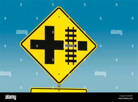 Yellow road sign depicting railroad crossing Stock Photo - Alamy