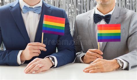 Close Up Of Male Gay Couple Holding Rainbow Flags Stock Image Image