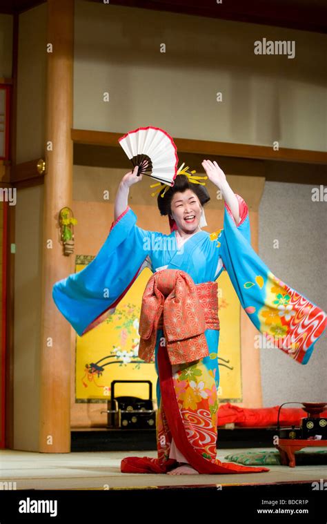 A Female Performer Dressed In Traditional Geisha Outfit Performs On