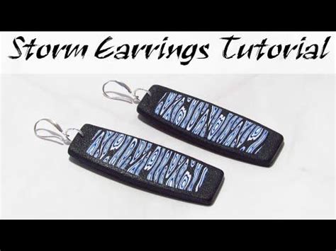 Two Earrings With Black And Blue Designs On Them