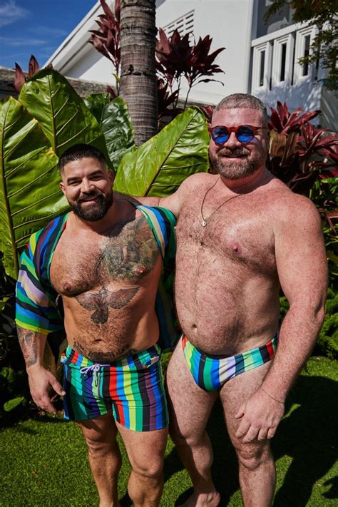 Two Men Standing Next To Each Other In Swim Trunks