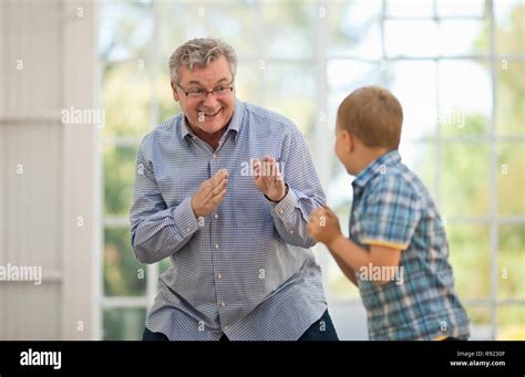 Laughing Mature Man Having A Play Fight With His Grandson Stock Photo Alamy