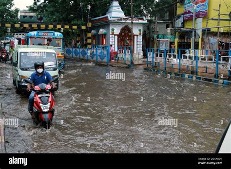 Commuters Wade Through A Waterlogged Street In Floodwaters Following