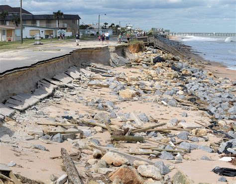 Onlookers Walk Past A Washed Out Portion Of State Highway A1A In The