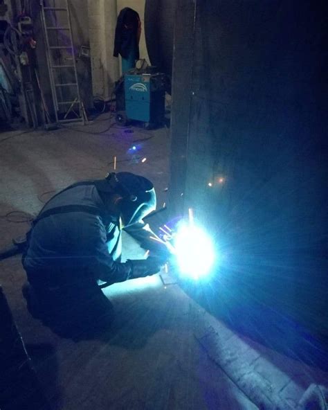 Welder Working On Something In The Dark With Blue Light Coming From It