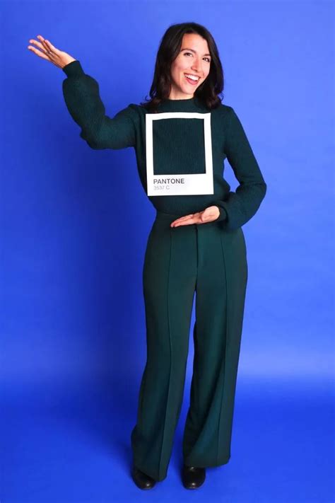 A Woman Wearing Green Pants And A Black Sweater Is Holding Her Arms Out