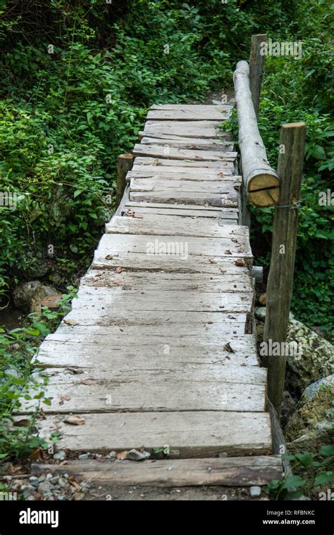 Wooden Bridge Made From Planks Of Wood In Forest With Handrail Stock