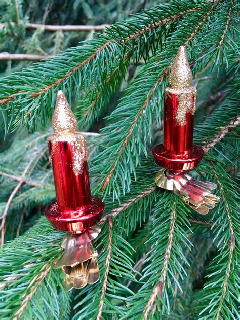 Two Red And Gold Christmas Lights Hanging From A Pine Tree