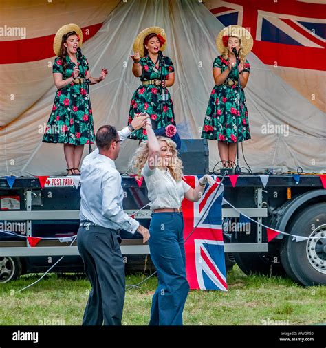 A Couple Dressed Up In 1940s Style Clothing Dancing Whilst A Female