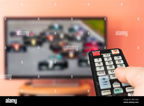 Caucasian Man Watching Formula 1 Race On Tv At Home Changing Channels