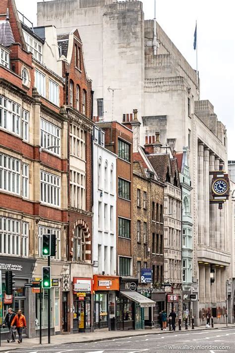 people are walking down the street in front of buildings