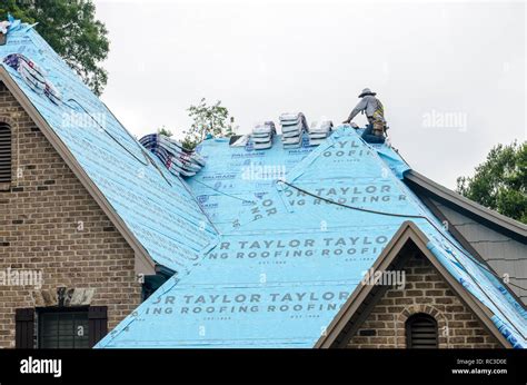 Roofing Contractors Replacing Damaged Roofs After A Hail Storm Stock