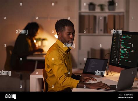 Portrait Of African American It Developer Writing Code On Multiple