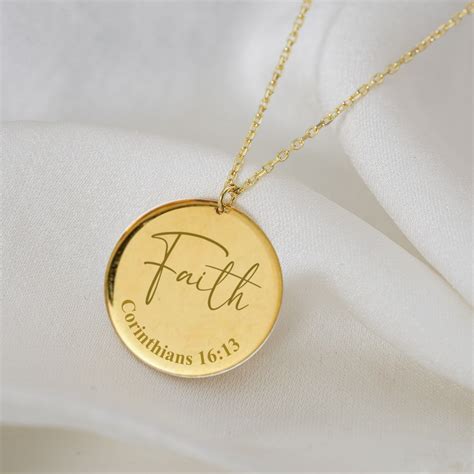 A Gold Necklace With The Word Faith Engraved On It