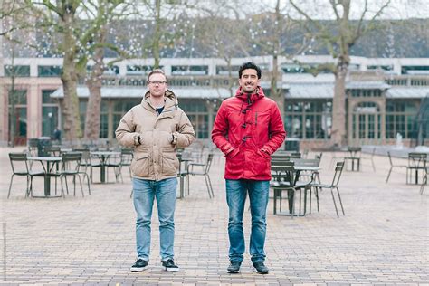 Two Friends Standing Next To Eachother Looking At The Camera By