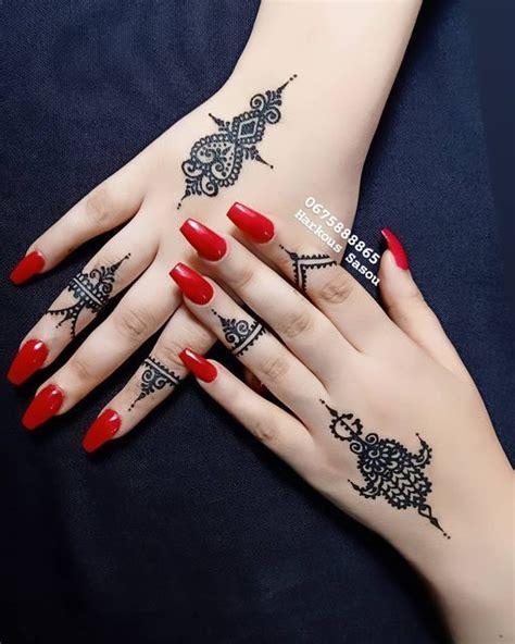 Two Hands With Henna Tattoos On Them And Red Nail Polish One Is