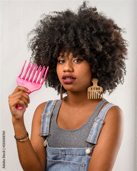 Foto De Jovem Mulher Cabelo Estilo Afro Segurando Um Pente Garfo