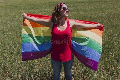 Woman Holding The Gay Rainbow Flag On A Green Meadow Outdoors Happiness Freedom And Love