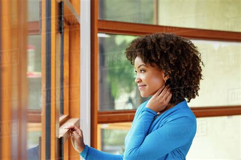 Smiling Black Woman Looking Out Window Stock Photo Dissolve