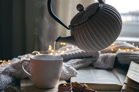 Gemütliche komposition mit einer teekanne einer tasse und einem buch