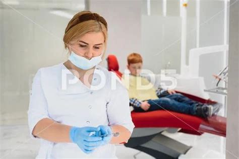 Portrait Of A Dentist Holding Dental Instruments In His Hands In The