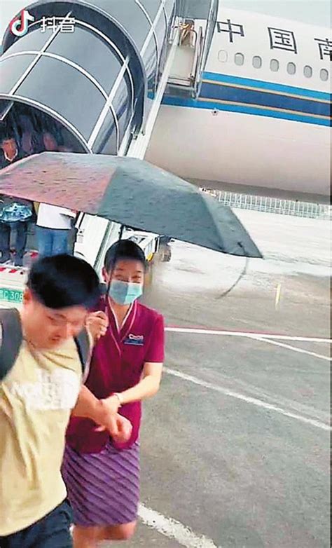 台风暴雨中，深圳机场上演暖心一幕 空姐冒雨撑伞护送旅客上摆渡车深圳新闻网