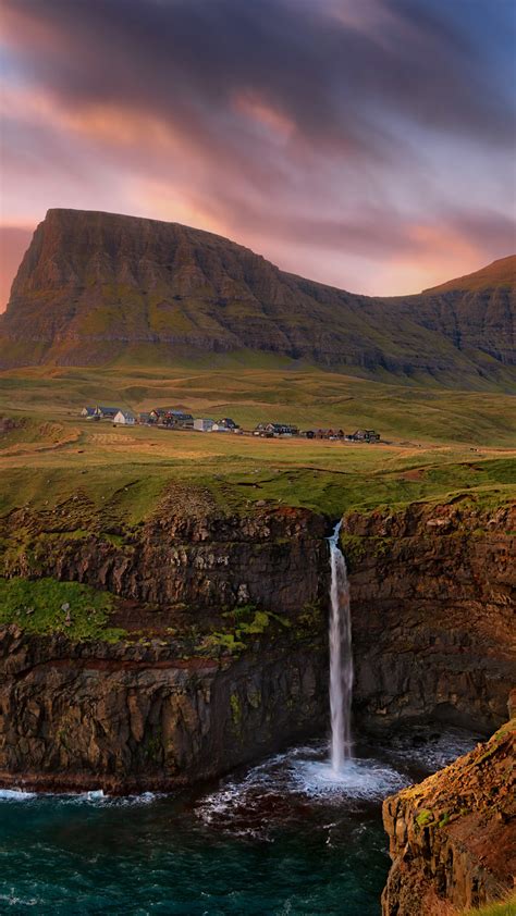 G Sadalur Village And Waterfall Falling Into The Ocean In Faroe Islands