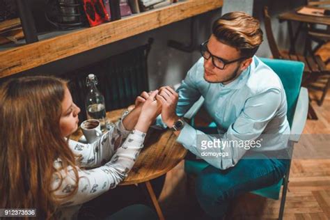 Smiling Couple Holding Hands And Drinking Coffee In Cafe Photos And