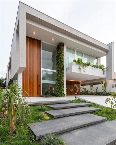 A Modern House With Stairs Leading Up To The Front Door