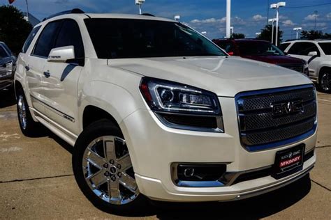 The Front End Of A White Suv Parked In A Parking Lot