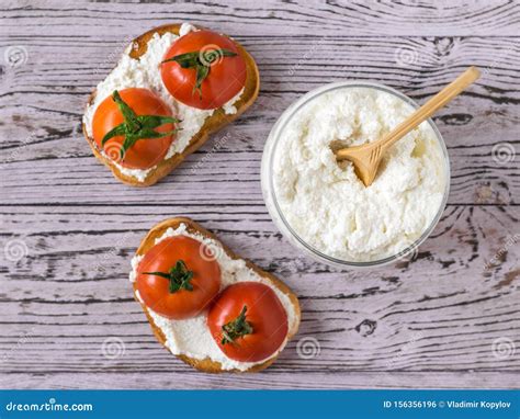 Two Toast With Tomatoes And Cottage Cheese On A Wooden Table The View