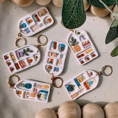 Four Keychains With Different Designs On Them Sitting Next To Some