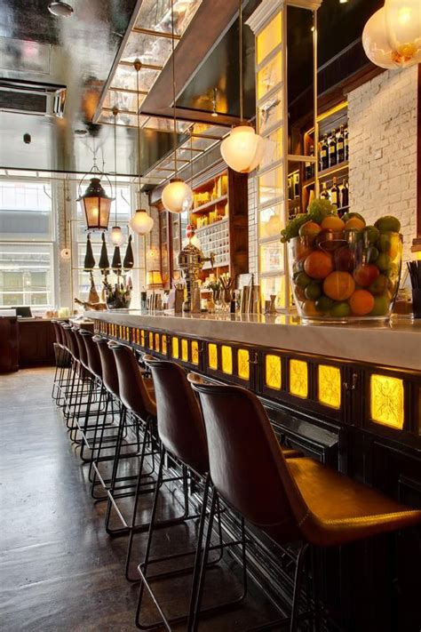 A Bar With Lots Of Stools And Lights Hanging From It S Ceiling Above