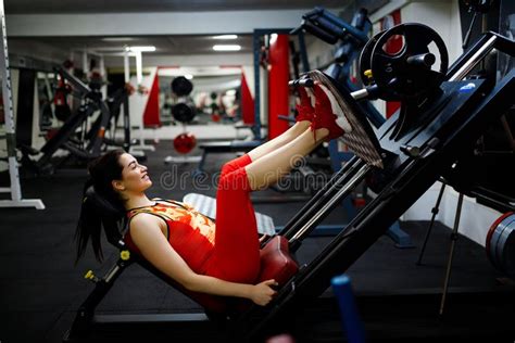 Girl In The Gym Goes In For Sports On Exercise Machines Stock Image