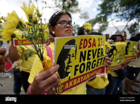 A Filipino Activist Displays Flowers And Slogans Bearing An Image Of